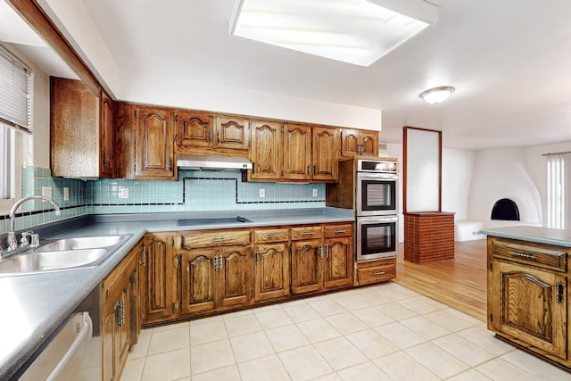 kitchen with backsplash, range hood, double oven, and sink