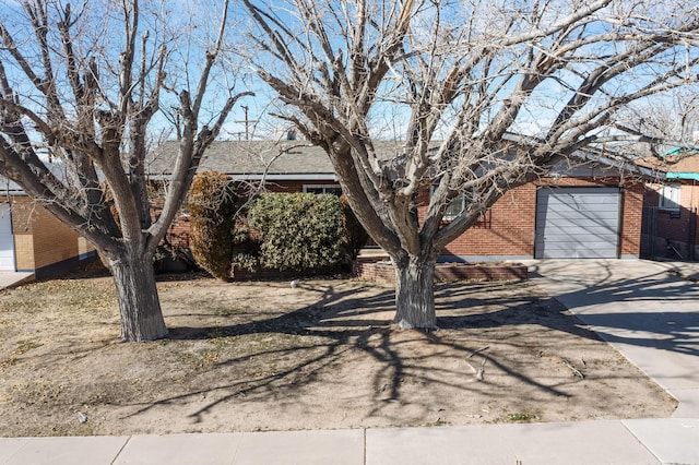 view of property hidden behind natural elements featuring a garage