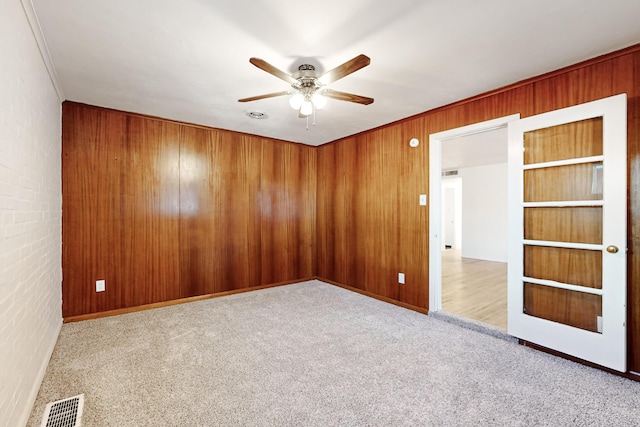 carpeted spare room with ceiling fan and crown molding