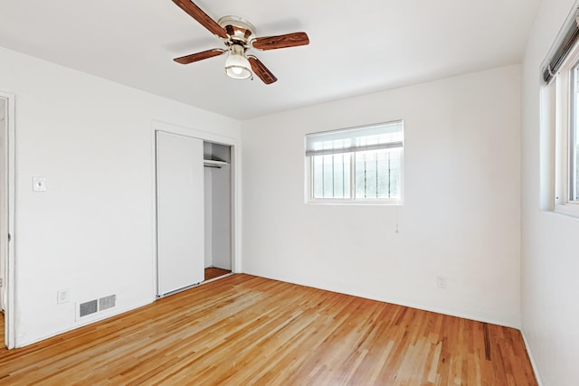 unfurnished bedroom with hardwood / wood-style floors, ceiling fan, and a closet