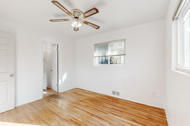 unfurnished bedroom with ceiling fan, wood-type flooring, and multiple windows