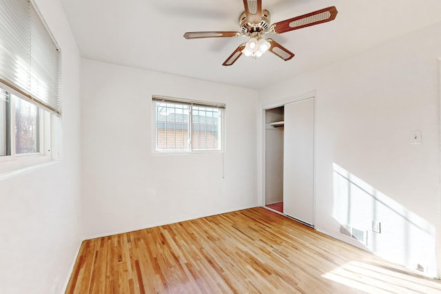 unfurnished bedroom with hardwood / wood-style floors, a closet, and ceiling fan