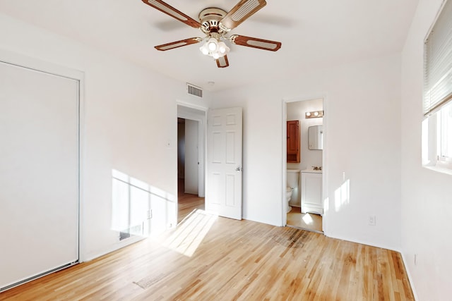 unfurnished bedroom featuring ensuite bathroom, ceiling fan, and light hardwood / wood-style floors