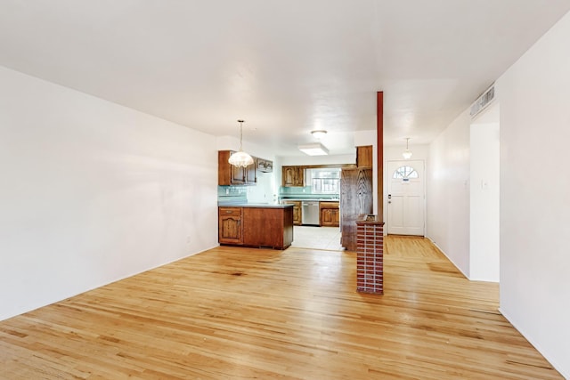 kitchen featuring dishwasher, a kitchen island, light hardwood / wood-style floors, and decorative light fixtures