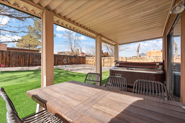 wooden deck featuring a lawn and a hot tub