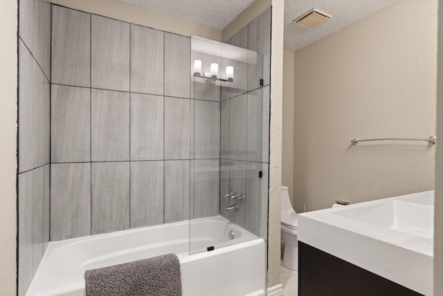 bathroom featuring toilet, shower / bath combination, and a textured ceiling