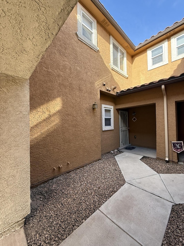 view of exterior entry with a patio