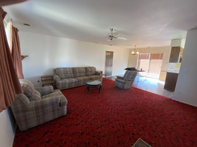 living room featuring ceiling fan with notable chandelier