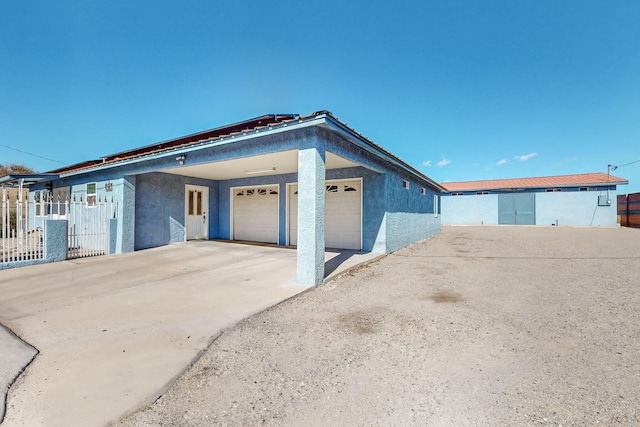 415 Wheeler Ave SE, Albuquerque, NM 87102 - view of front of house featuring stucco siding, a garage, fence, and driveway