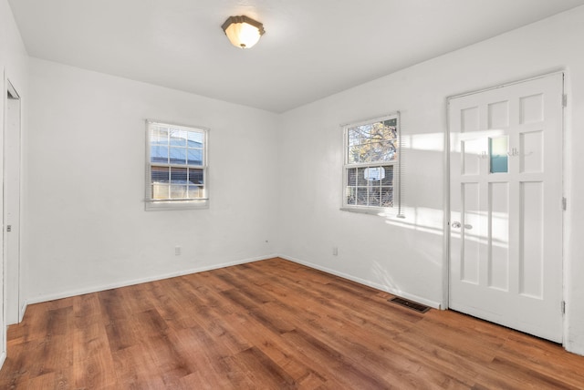 empty room with hardwood / wood-style flooring