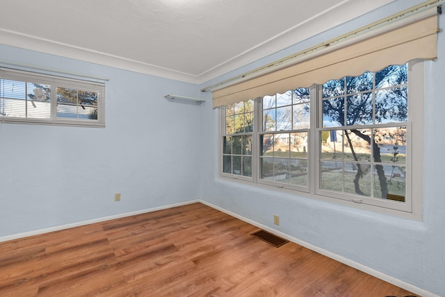 spare room featuring hardwood / wood-style flooring and ornamental molding