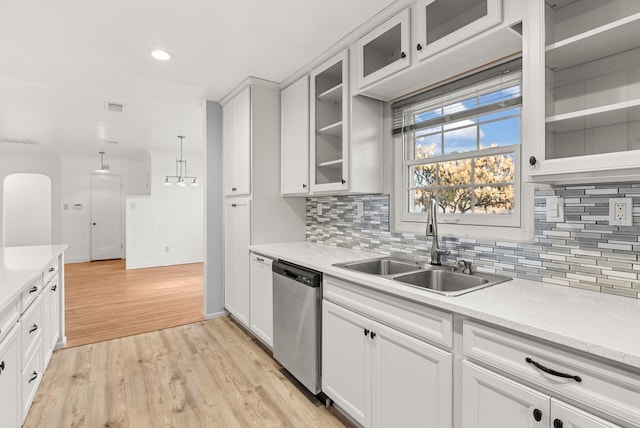 kitchen with sink, stainless steel dishwasher, light wood-type flooring, decorative light fixtures, and white cabinetry