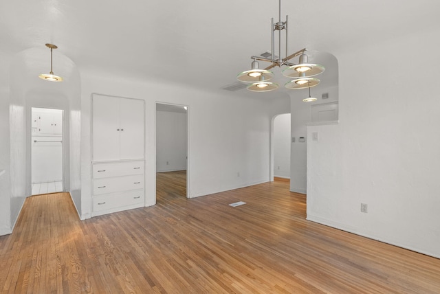 empty room featuring hardwood / wood-style floors and a notable chandelier