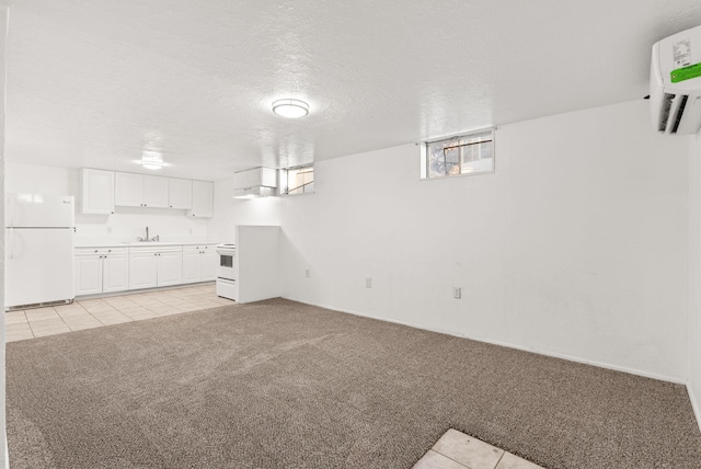 unfurnished living room featuring light carpet, a wall mounted air conditioner, and a textured ceiling