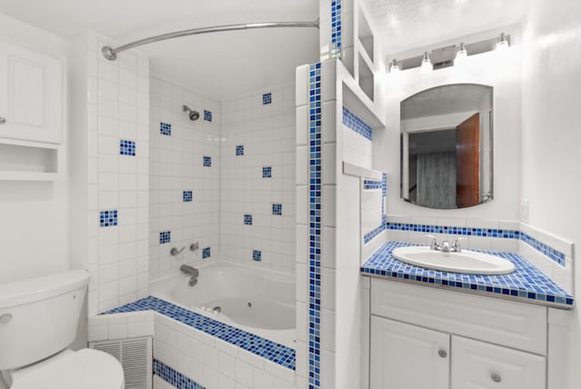 full bathroom featuring vanity, tasteful backsplash, toilet, and tiled shower / bath