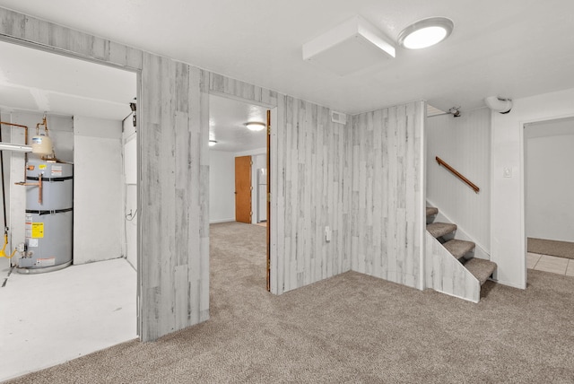 basement featuring water heater and light carpet