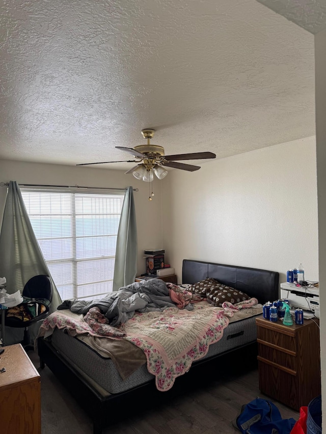 bedroom with a textured ceiling, ceiling fan, and wood finished floors