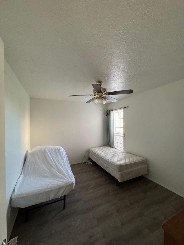 bedroom featuring a textured ceiling, a ceiling fan, and wood finished floors