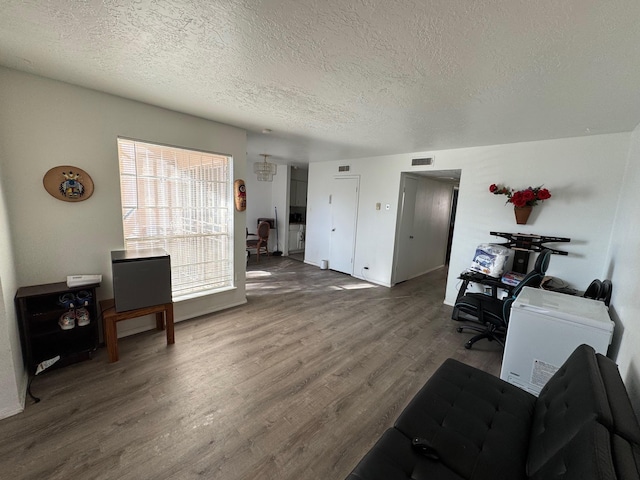 office area featuring visible vents, a textured ceiling, and wood finished floors