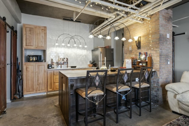 bar featuring stainless steel fridge, a barn door, brick wall, and wooden counters