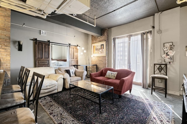 interior space with a barn door, concrete flooring, and brick wall