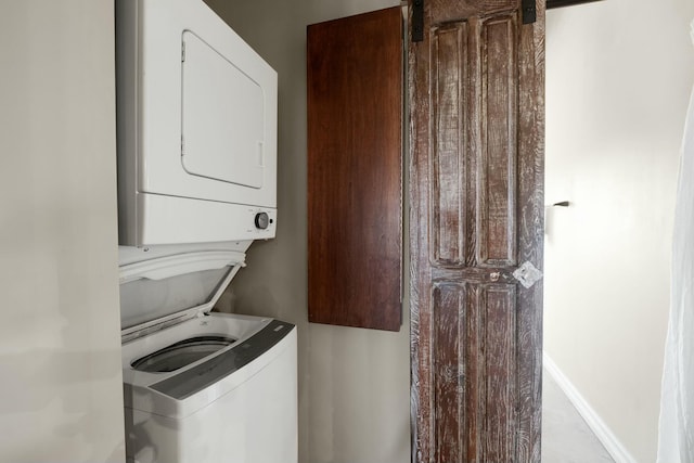 clothes washing area featuring stacked washer and clothes dryer