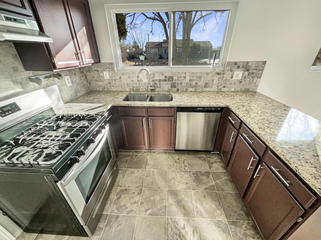 kitchen with appliances with stainless steel finishes, tasteful backsplash, light stone counters, ventilation hood, and sink