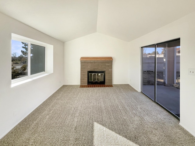 unfurnished living room with carpet flooring, lofted ceiling, and a fireplace