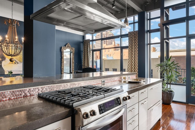 kitchen with stainless steel range oven, extractor fan, white cabinetry, dark hardwood / wood-style flooring, and a notable chandelier