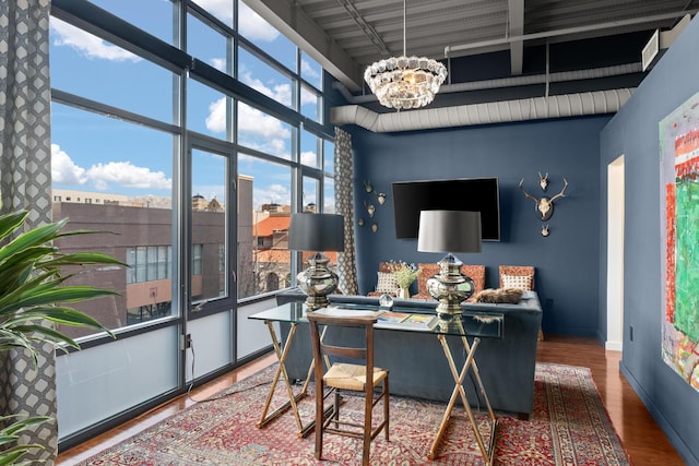 interior space featuring hardwood / wood-style flooring, a high ceiling, a healthy amount of sunlight, and an inviting chandelier