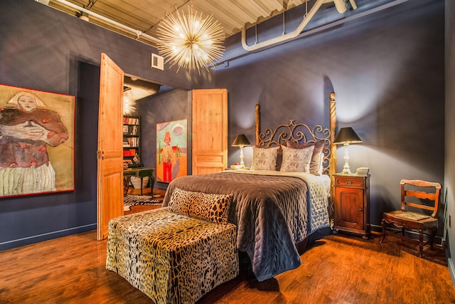 bedroom featuring dark hardwood / wood-style flooring and a notable chandelier