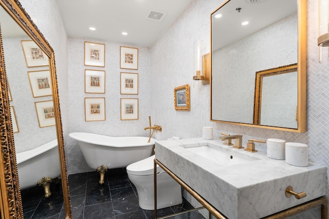 bathroom with vanity, toilet, and a washtub