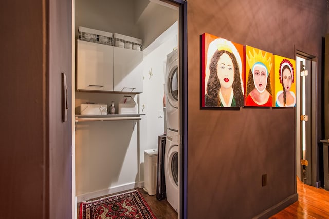 washroom with stacked washer and dryer and hardwood / wood-style flooring