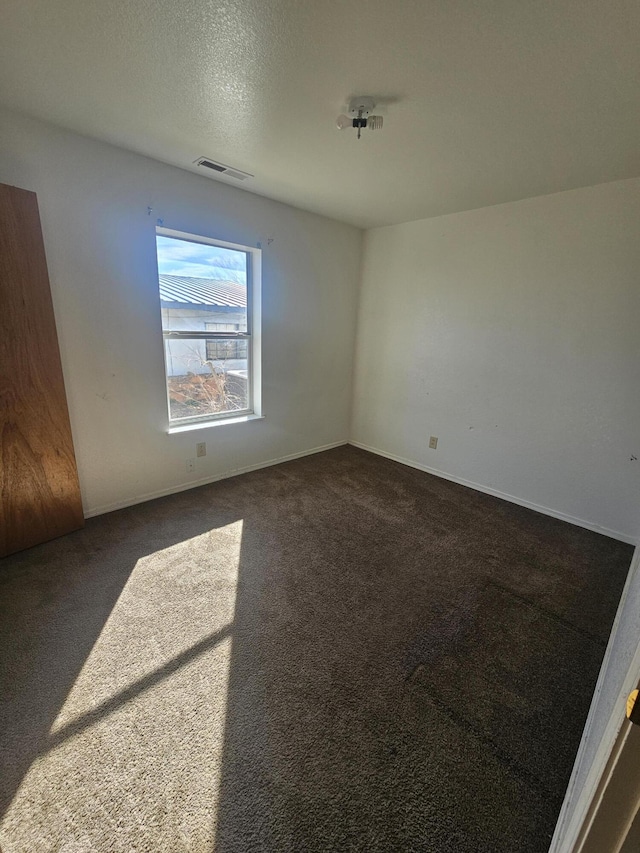 carpeted spare room with a textured ceiling