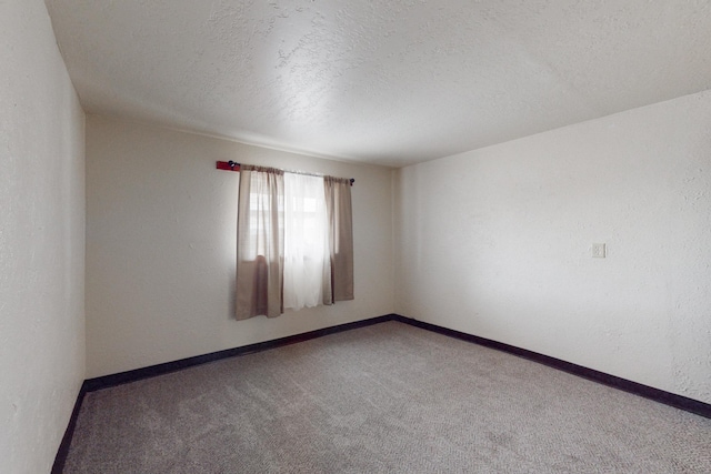 carpeted empty room featuring a textured ceiling