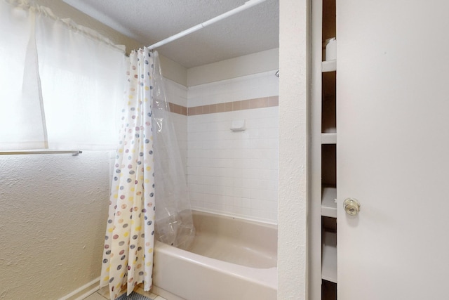 bathroom featuring shower / bath combo and a textured ceiling