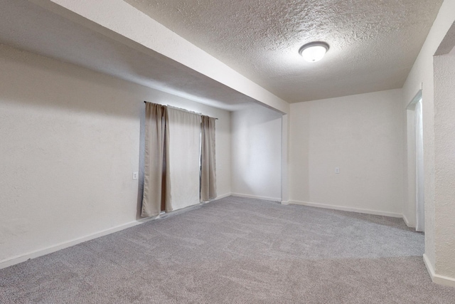 carpeted empty room with a textured ceiling