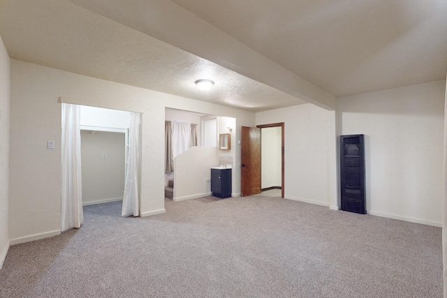 interior space featuring a textured ceiling and light carpet