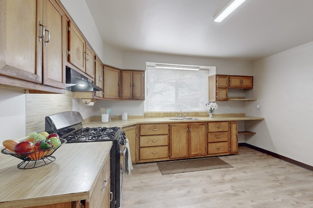 kitchen with light wood-type flooring, sink, and stainless steel range with gas stovetop