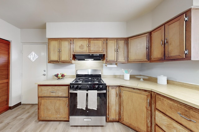 kitchen with light wood-type flooring, range hood, and stainless steel gas range