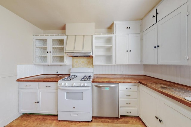 kitchen featuring white gas stove, white cabinets, stainless steel dishwasher, and custom range hood