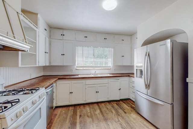 kitchen featuring wood counters, white cabinets, sink, light hardwood / wood-style flooring, and appliances with stainless steel finishes