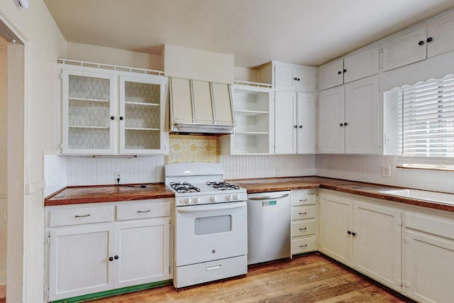 kitchen featuring light wood-type flooring, stainless steel dishwasher, sink, white cabinetry, and white gas stove