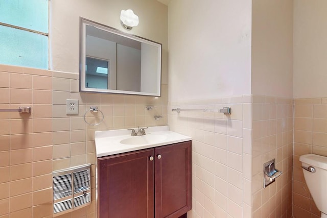 bathroom with vanity, tile walls, and toilet