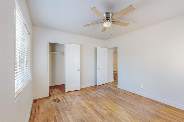 unfurnished bedroom featuring multiple windows, ceiling fan, a closet, and light hardwood / wood-style flooring