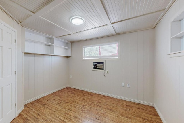 laundry room featuring light wood-type flooring and wood walls