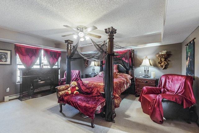 bedroom with ceiling fan, light colored carpet, baseboard heating, and a textured ceiling