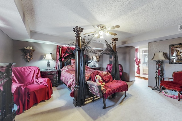 bedroom with a textured ceiling, ceiling fan, light colored carpet, and ensuite bathroom