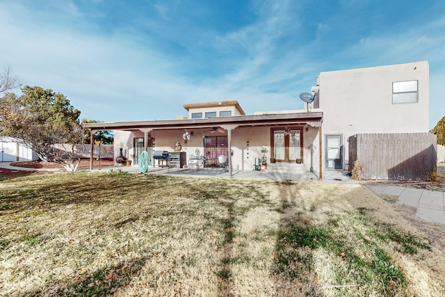 rear view of property featuring french doors, a yard, and a patio