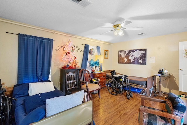 interior space with ceiling fan, wood-type flooring, and a textured ceiling